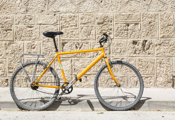 Fototapeta na wymiar isolated bicycle on a stone made wall background