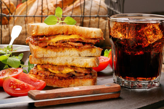 Sandwich with fried bacon on wooden background