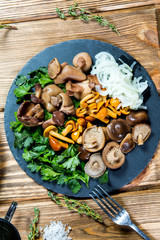 Fototapeta premium Beautiful different mushrooms with herbs and onions