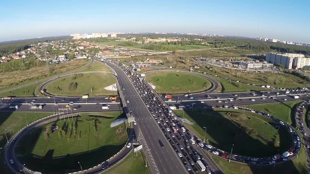 Aerial view of city traffic on highway typical cloverleaf interchange Urban transportation with traffic jams in industrial country side area