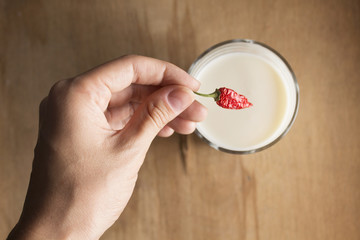 woman who puts it in a small glass of milk dried bitter pepper to taste