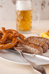 Closeup of bavarian cooked sausage and pretzel