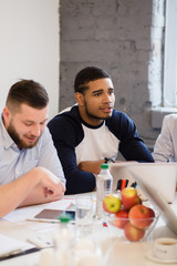 Picture of real business people working round table in office interior. Happy people discussing burning business issues or problems.
