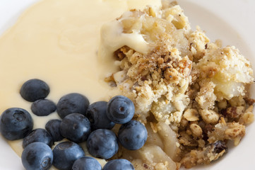 Apple crumble with blackcurrants and custard