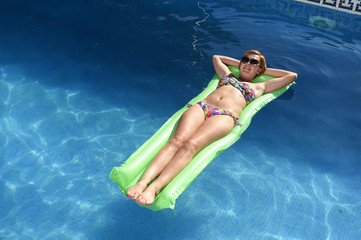 beautiful woman in bikini lying relax on float airbed at vacacti