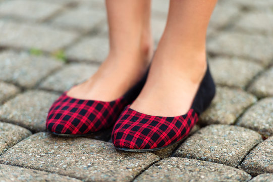 Close Up Of Red And Black Plaid Ballerinas On Child's Feet