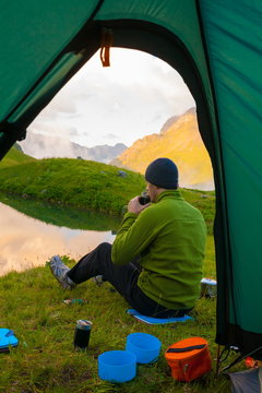 A man in mountain day summer. View from tent