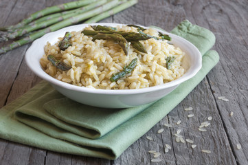 Rice with asparagus on wooden table