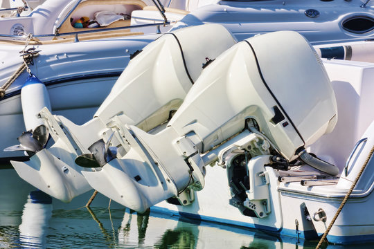 Pair of white outboard engines mounted on white boat