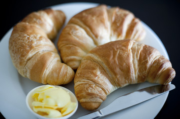 Three golden flaky croissants