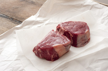 Two raw thick juicy eye fillet steaks