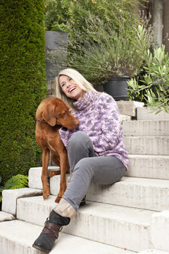 Frau mittleren Alters schmust mit Hund