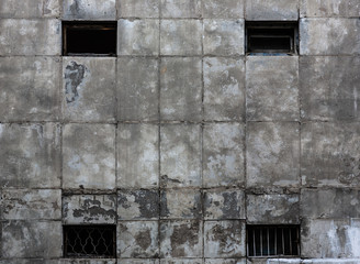 Fototapeta na wymiar abstraction gray dirty wall with windows, the prison building