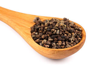 Decorticated cardamom seeds in a wooden spoon