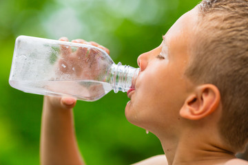 Child drinking clean tap water from transparent plastic bottle - obrazy, fototapety, plakaty