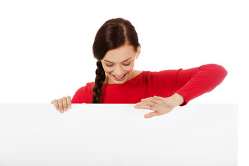 Young smiling woman holding blank banner