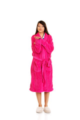 Woman in pink bathrobe showing empty palm.