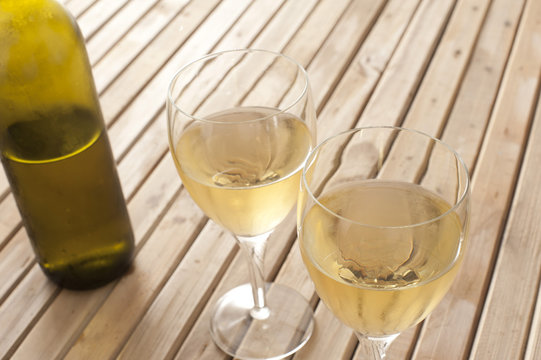Glasses of white wine with a bottle