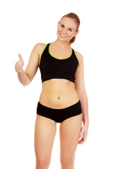 Fototapeta premium Young athletic woman showing thumb up