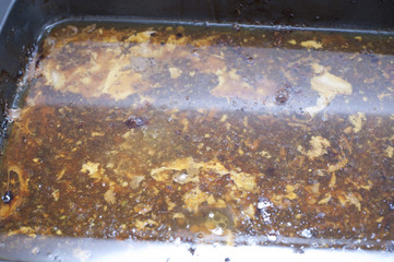 Exuded juices and dripping in a pan for basting