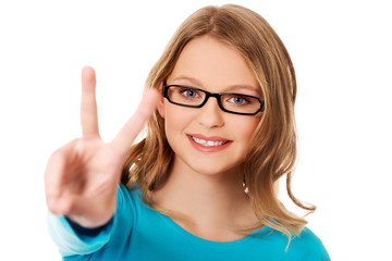 Obraz premium Happy teenager showing victory sign