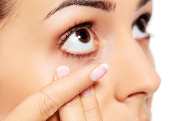 Closeup of young woman wearing contact lens.