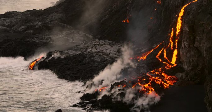 Volcanic Eruption Lava flowing into the ocean Hawaii. Steam rising from waves as molten lava flows into ocean waters Big Island Hawaii.