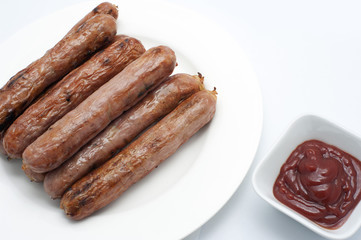 Plate of grilled sausages with tomato ketchup