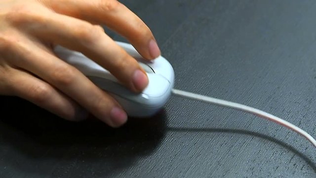 Mouse 5. Soft focus to hand of the man clicking left mouse button. Right hand from right top view.