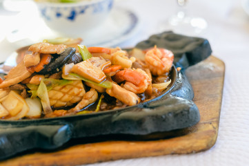 Closeup on mixed meat curry in pot on white table background