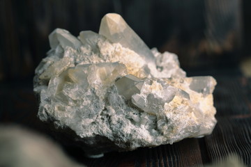 Rock crystal mineral stone on the wooden background. Quartz variety.