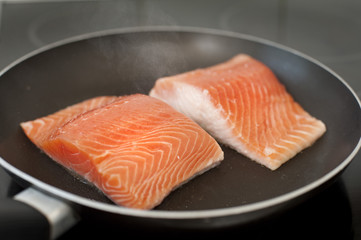 Frying salmon steaks in a pan