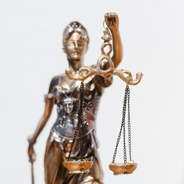 Sculpture of justice, femida or themis goddess on light copy space background