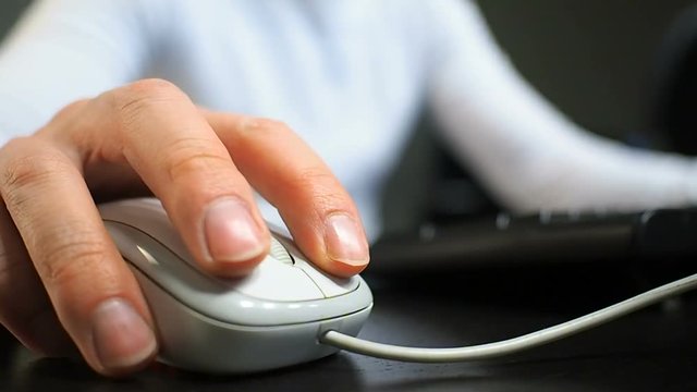 Mouse 14. Soft focus to hand of the man clicking left mouse button. Right hand from front right front view.