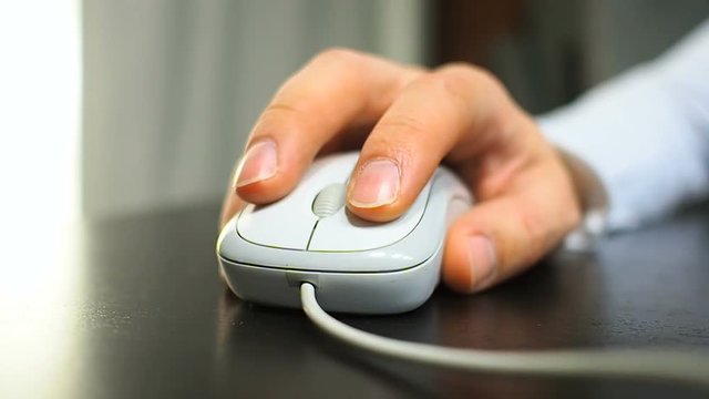 Mouse 17. Soft focus to hand of the man clicking left mouse button. Right hand from front view.
