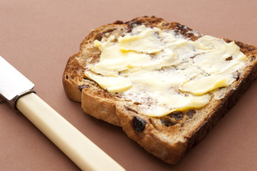 Slice of buttered toasted raisin bread