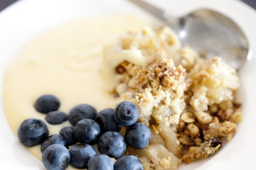 Apple crumble served with blackberries