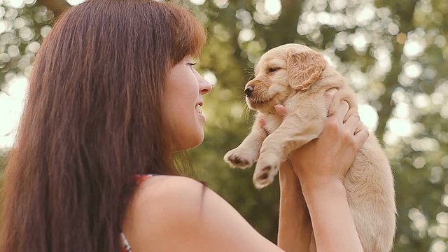 Girl plays with a little puppy