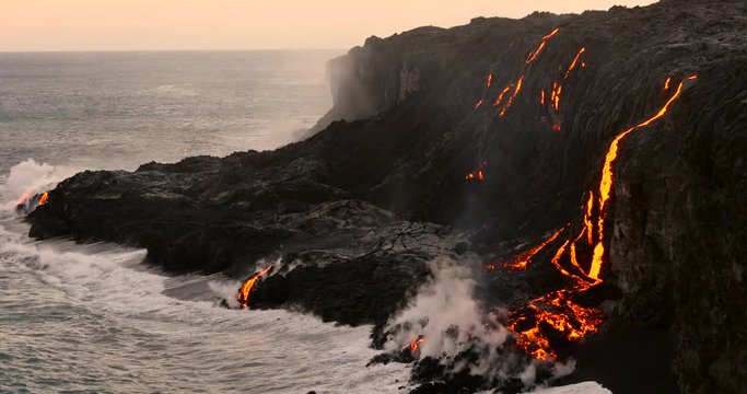 Volcanic Eruption Lava flowing into the ocean Hawaii. Steam rising from waves as molten lava flows into ocean waters Big Island Hawaii