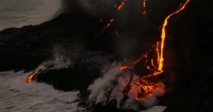Volcanic Eruption Lava flowing into the ocean Hawaii. Steam rising from waves as molten lava flows into ocean waters Big Island Hawaii