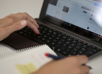 mujer realizando contabilidad doméstica  en ordenador portatil