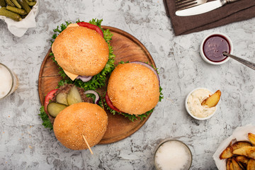 Burgers grilled on wooden round board with light beer