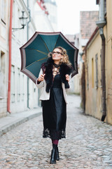 Fototapeta na wymiar Attractive, stylish woman walking with an umbrella