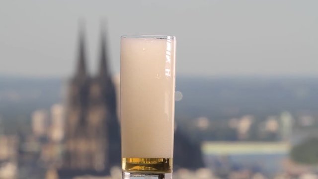famous german beer called K&ouml;lsch pouring in a beer glas in front of the cologne cathedral