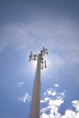 Obraz premium Telecommunication mast television antennas on blue sky. Site, mobile operator antenna or aerial. Cell phone base station, mobile phone network. Cell site, cell tower or cellular telephone site.