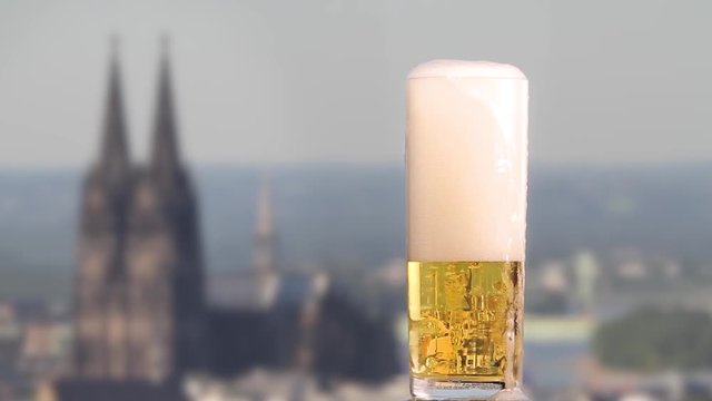 famous german beer called K&ouml;lsch pouring in a beer glas in front of the cologne cathedral