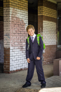 Cute boy with a school satchel having fun about school
