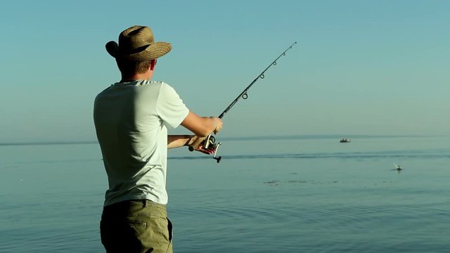 Fisherman on the lake in a cowboy hat.
