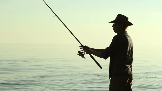 Fisherman on the lake in a cowboy hat.