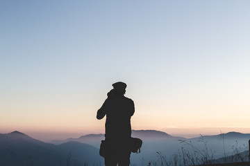 landscape view of great mountains andman silhouette,taking picture